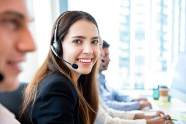 Smiling lady working at call center with colleagues in office